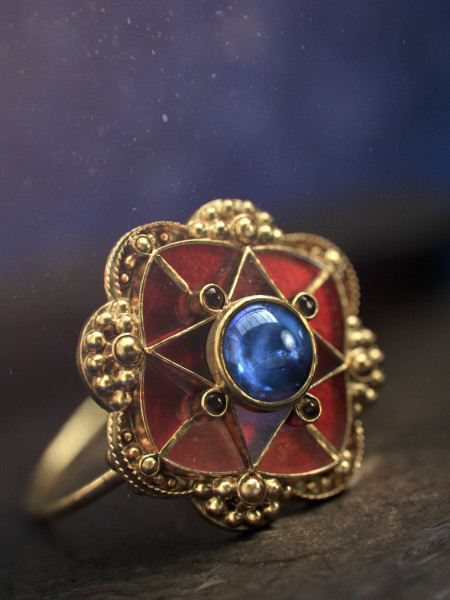 Rendered golden ring with red decorations and a blue gem